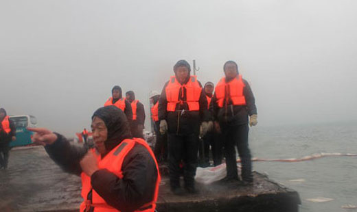 青岛华海环保工业有限公司员工冒寒风顶冷雨清理胶州湾溢油